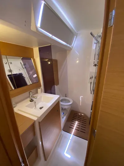  Yacht Photos Pics Bathroom interior of 2017 Dufour Exclusive 56 yacht, featuring modern fixtures and wooden accents.
