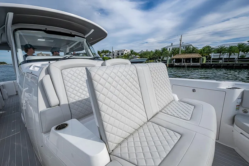  Yacht Photos Pics 2023 Intrepid 427 Nomad SE boat with luxurious seating and scenic waterfront view.