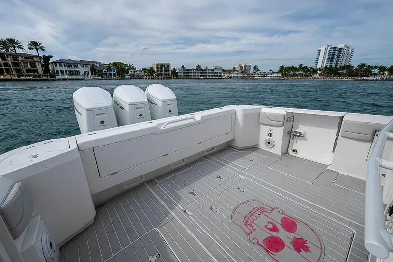  Yacht Photos Pics 2023 Intrepid 427 Nomad SE boat deck with triple Mercury engines, coastal view.