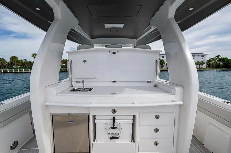  Yacht Photos Pics 2023 Intrepid 427 Nomad SE boat interior with kitchenette and storage, docked by the water.