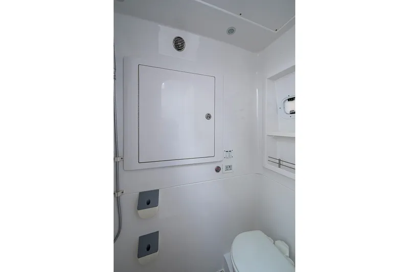  Yacht Photos Pics 2023 Intrepid 427 Nomad SE boat bathroom with white interior and compact design.