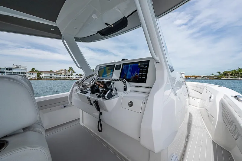  Yacht Photos Pics 2023 Intrepid 427 Nomad SE boat cockpit with advanced navigation system, docked by waterfront homes.