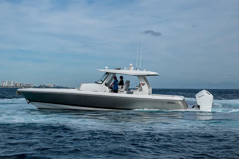  Yacht Photos Pics 2023 Intrepid 427 Nomad SE boat cruising on open water, city skyline in background.