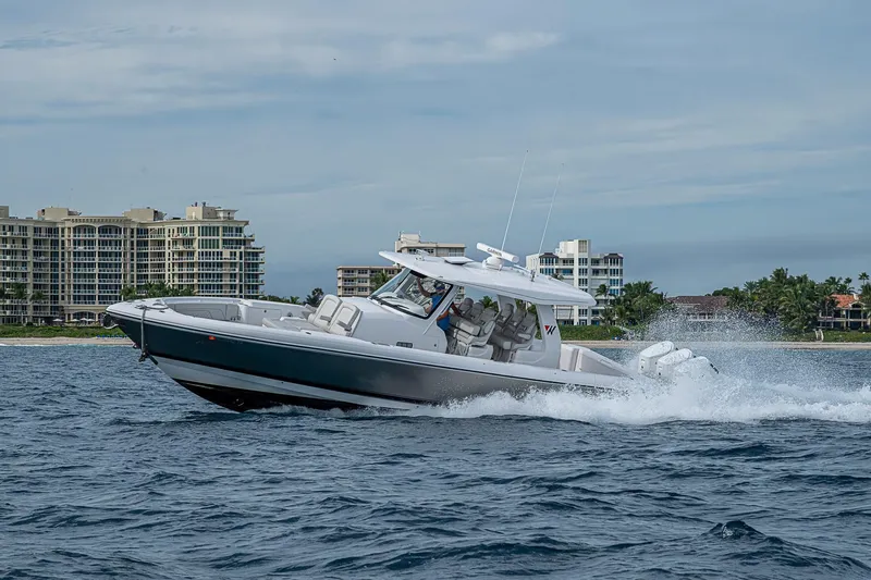 Yacht Photos Pics 2023 Intrepid 427 Nomad SE cruising on water near coastal buildings.