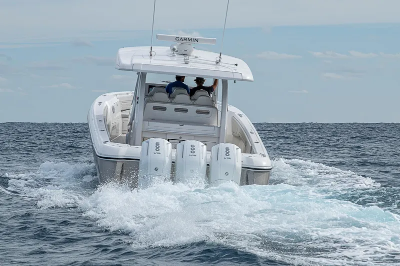  Yacht Photos Pics 2023 Intrepid 427 Nomad SE boat cruising on open water, rear view.