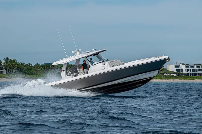  Yacht Photos Pics 2023 Intrepid 427 Nomad SE cruising on open water near coastline.