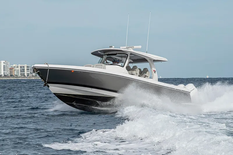  Yacht Photos Pics 2023 Intrepid 427 Nomad SE cruising on ocean waves near city skyline.