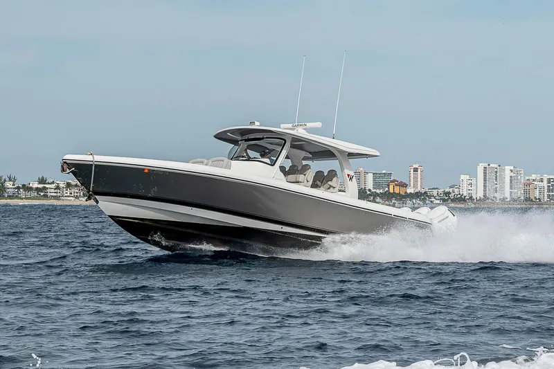  Yacht Photos Pics 2023 Intrepid 427 Nomad SE cruising on open water near city skyline.