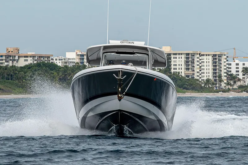  Yacht Photos Pics 2023 Intrepid 427 Nomad SE cruising on water near coastal buildings.