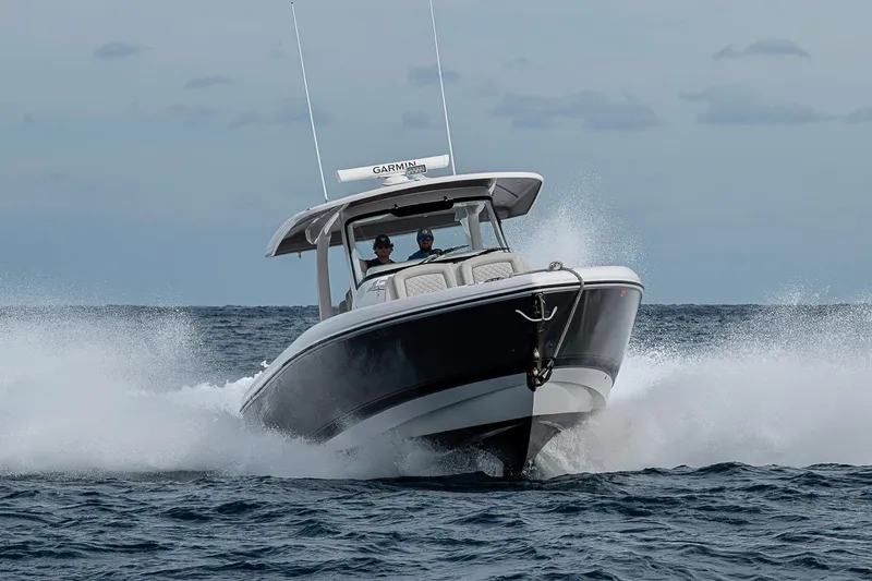  Yacht Photos Pics 2023 Intrepid 427 Nomad SE boat cruising on open water, creating splashes.