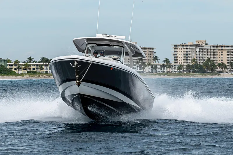  Yacht Photos Pics 2023 Intrepid 427 Nomad SE cruising on ocean near coastal buildings.