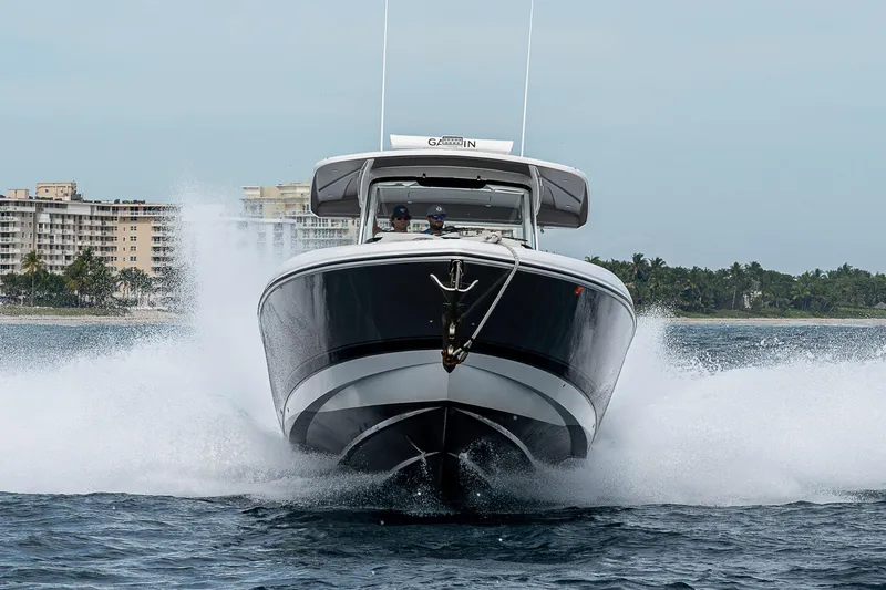  Yacht Photos Pics 2023 Intrepid 427 Nomad SE cruising on water with cityscape background.