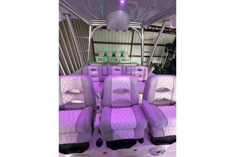  Yacht Photos Pics Interior of 2025 Contender 44 ST boat with purple-lit seating and modern design.