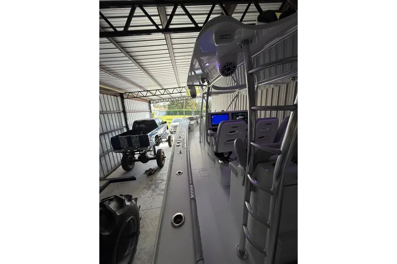  Yacht Photos Pics 2025 Contender 44 ST boat interior in a garage with a lifted truck nearby.