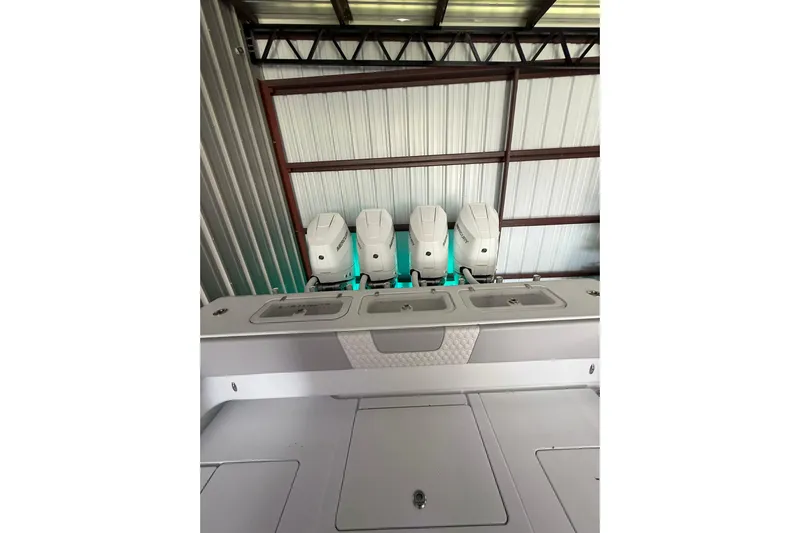  Yacht Photos Pics 2025 Contender 44 ST boat with four powerful outboard engines in a metal storage facility.