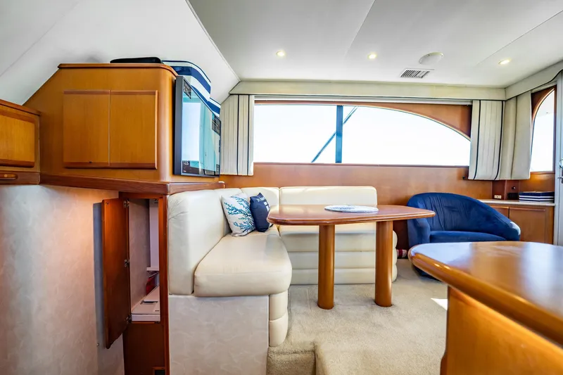 Business Yacht Photos Pics Luxurious yacht interior with wooden furnishings, cream seating, and large windows, Post 42 model, 2001.