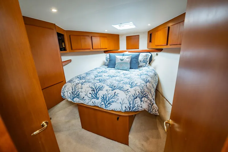 Business Yacht Photos Pics Luxurious cabin interior of 2001 Post 42 yacht with cozy bed and wooden cabinetry.