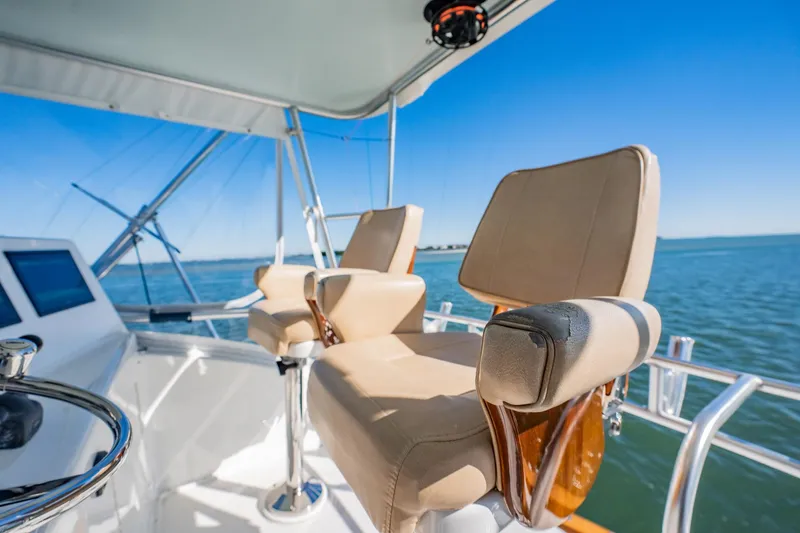 Business Yacht Photos Pics Luxury yacht helm with beige seats, Post 42 model, 2001, overlooking serene ocean.