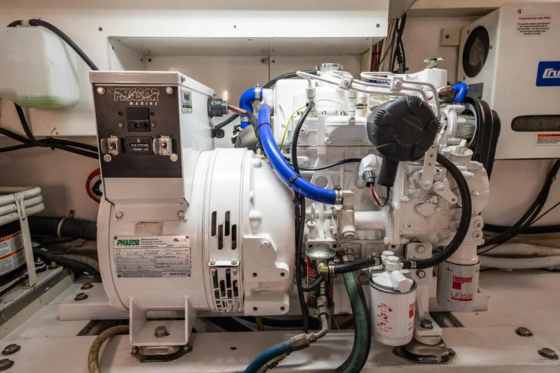 Business Yacht Photos Pics Phasor Marine generator in engine room, featuring blue hoses and labeled components.