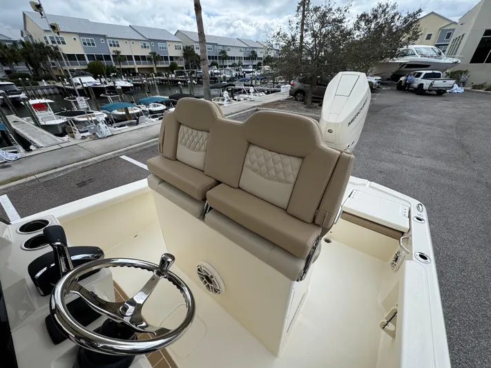  Yacht Photos Pics 2025 Scout 261 XSS boat interior with dual seats and steering wheel, docked at marina.
