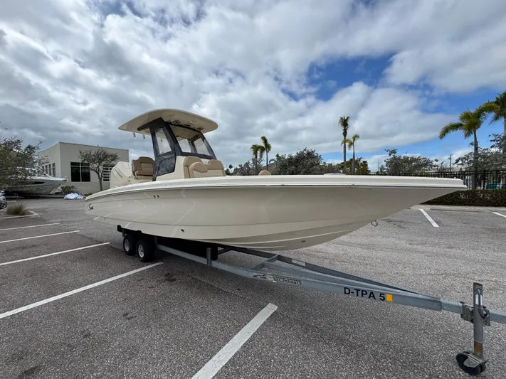  Yacht Photos Pics 2025 Scout 261 XSS boat on trailer in parking lot, under cloudy sky.