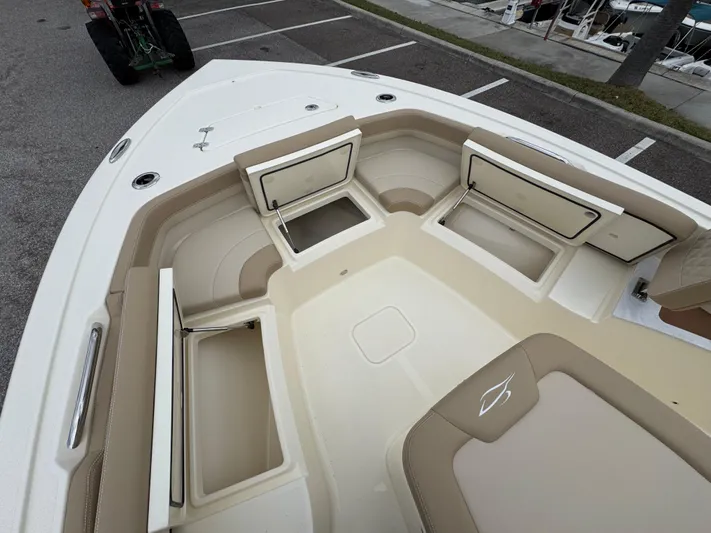  Yacht Photos Pics 2025 Scout 261 XSS boat interior with open storage compartments and beige seating.