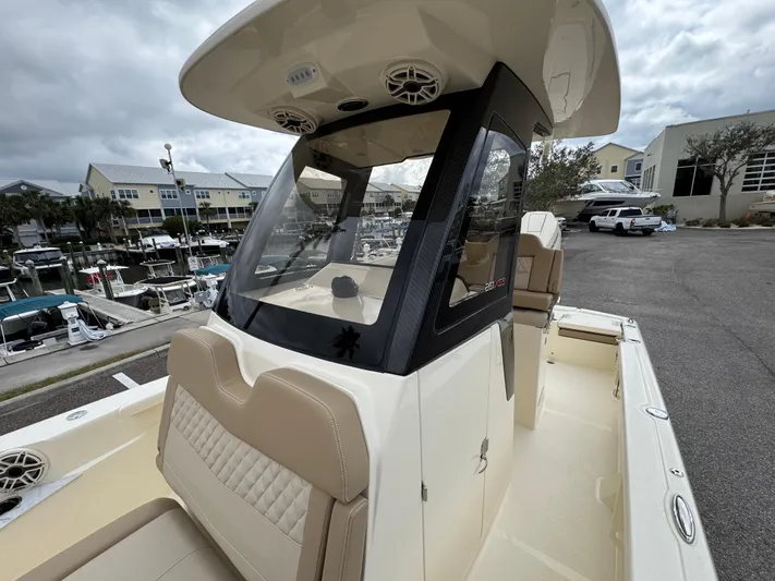  Yacht Photos Pics 2025 Scout 261 XSS boat with beige seating and modern console at a marina.