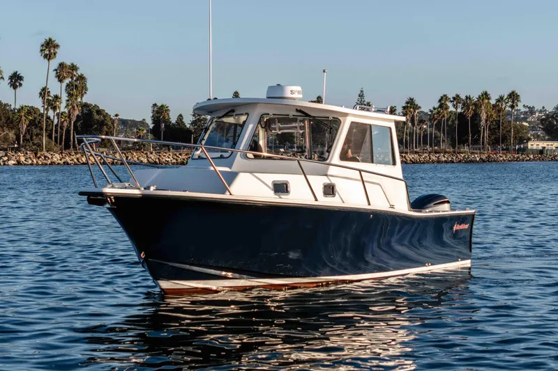 Caroline II Yacht Photos Pics 2021 NorthCoast 285 HT boat on calm water with palm trees in the background.