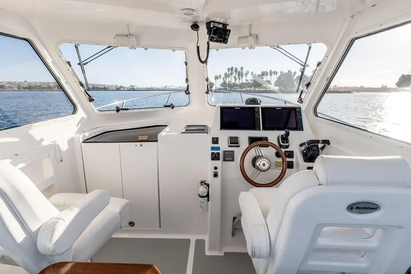 Caroline II Yacht Photos Pics Interior of 2021 NorthCoast 285 HT boat with steering wheel and navigation screens.