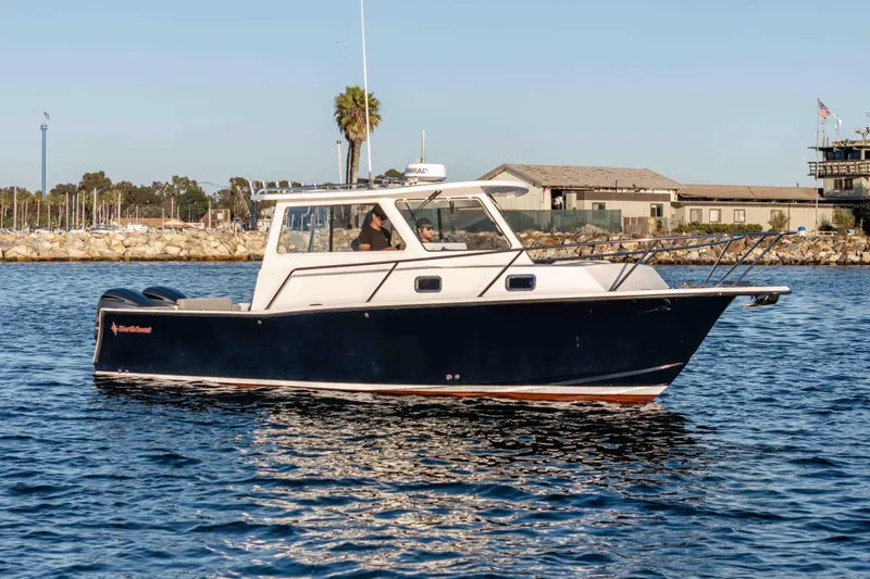 Caroline II Yacht Photos Pics 2021 NorthCoast 285 HT boat cruising on calm waters near a marina.