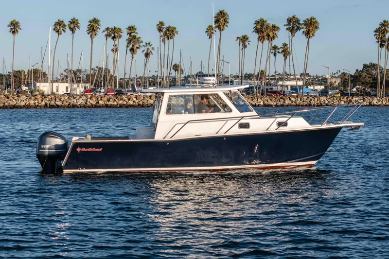 Caroline II Yacht Photos Pics 2021 NorthCoast 285 HT boat cruising on water with palm trees in the background.