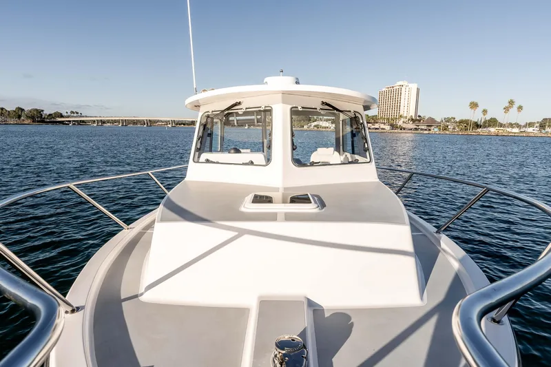 Caroline II Yacht Photos Pics 2021 NorthCoast 285 HT boat on calm water with cityscape background.