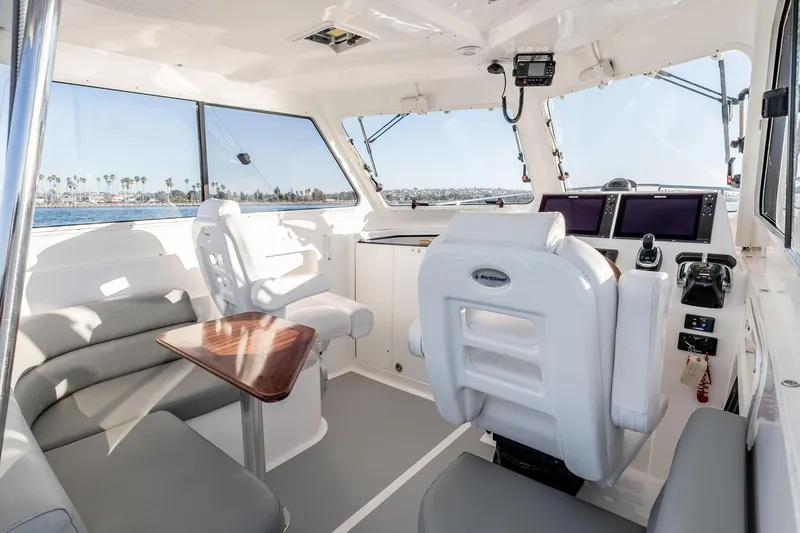 Caroline II Yacht Photos Pics Interior of 2021 NorthCoast 285 HT boat with helm, seating, and navigation equipment.