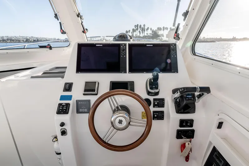 Caroline II Yacht Photos Pics Helm of 2021 NorthCoast 285 HT boat with dual Simrad displays and wooden steering wheel.