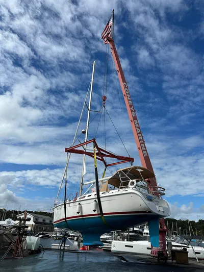  Yacht Photos Pics Hunter 38 sailboat from 2005 being lifted by crane at marina under blue sky.