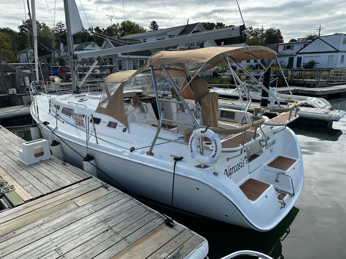  Yacht Photos Pics 2005 Hunter 38 sailboat docked at marina with tan canopy and white hull.