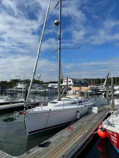  Yacht Photos Pics 2005 Hunter 38 sailboat docked at a marina under a partly cloudy sky.