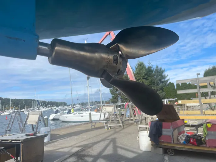  Yacht Photos Pics Propeller of 2005 Hunter 38 sailboat at marina with boats in background.