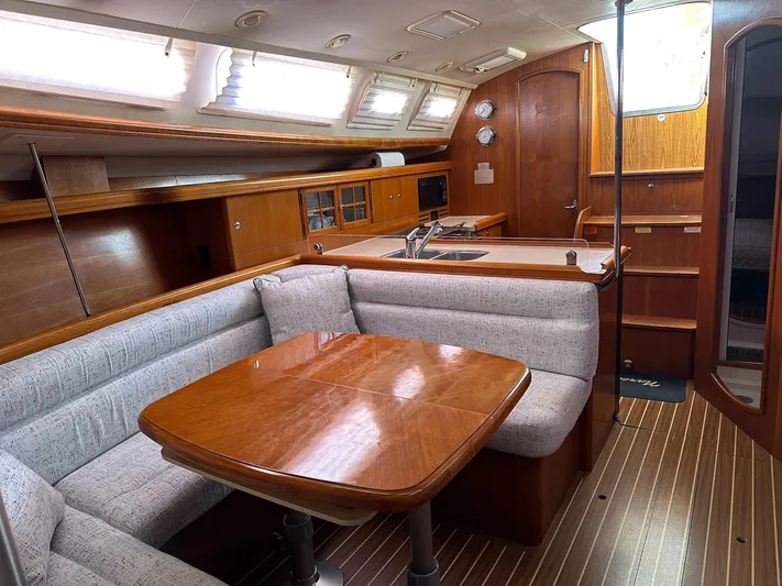  Yacht Photos Pics Interior of 2005 Hunter 38 sailboat with wooden dining area and kitchenette.