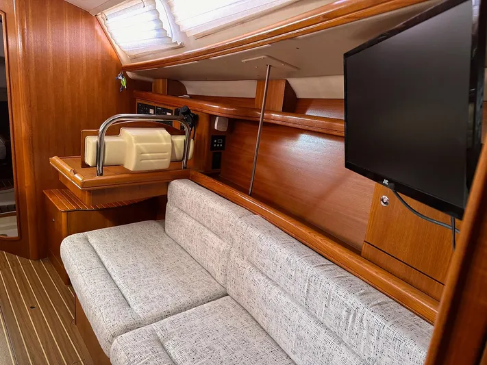 Yacht Photos Pics Interior of 2005 Hunter 38 yacht with sofa, TV, and wooden cabinetry.