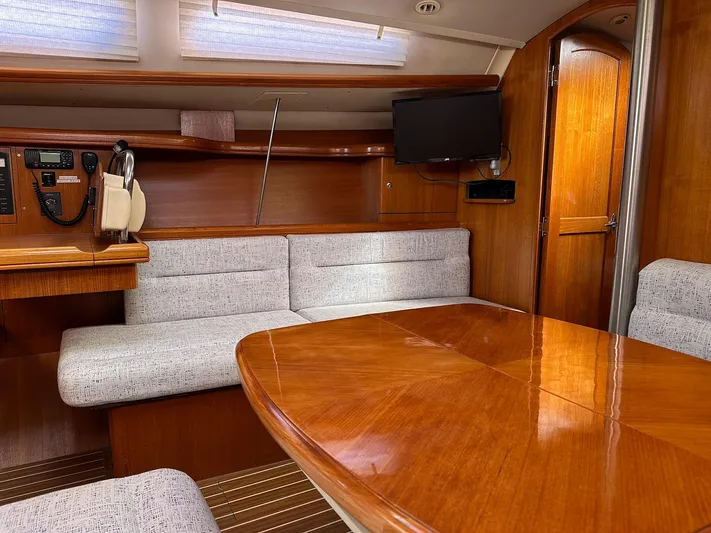  Yacht Photos Pics Interior of 2005 Hunter 38 sailboat with wood finish, seating, and mounted TV.