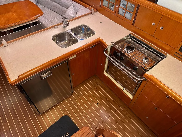  Yacht Photos Pics Luxurious 2005 Hunter 38 yacht kitchen with wood flooring, dual sink, and stainless steel appliances.