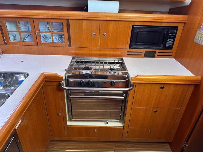  Yacht Photos Pics Hunter 38 yacht kitchen with stove, microwave, and wooden cabinetry, 2005 model.