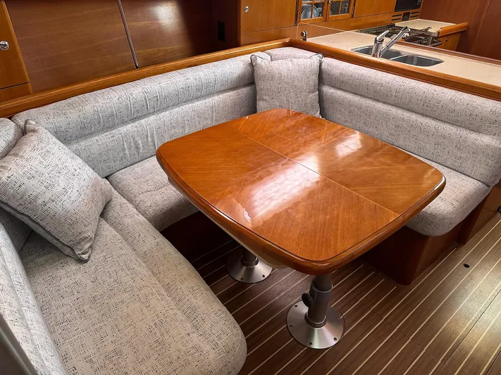  Yacht Photos Pics Cozy dining area in 2005 Hunter 38 yacht with wooden table and cushioned seating.