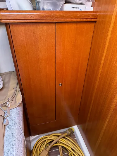 Yacht Photos Pics Wooden cabinet on a 2005 Hunter 38 sailboat with coiled hose nearby.