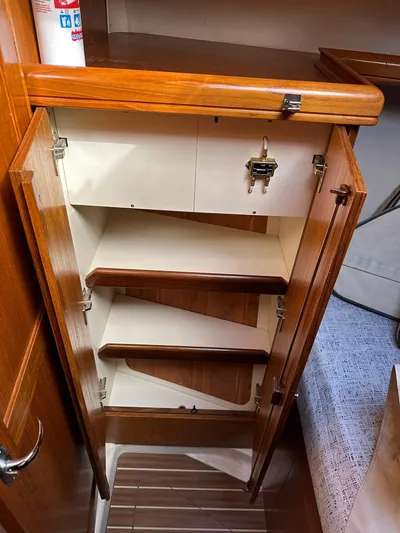  Yacht Photos Pics 2005 Hunter 38 sailboat interior cabinet with wooden shelves and secure latch.