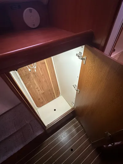  Yacht Photos Pics Open wooden cabinet door on 2005 Hunter 38 boat, revealing storage space.