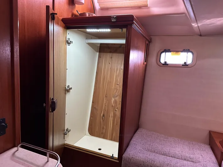  Yacht Photos Pics Interior of 2005 Hunter 38 sailboat with open wooden closet and cozy cabin space.