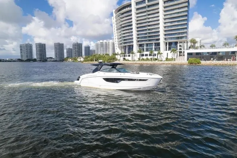  Yacht Photos Pics 2021 Cruisers Yachts 38 GLS OB on water near modern cityscape.