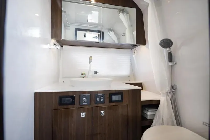  Yacht Photos Pics Luxurious bathroom in 2021 Cruisers Yachts 38 GLS OB with modern fixtures and wood cabinetry.